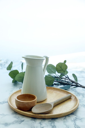Decorative setting Ceramic Jug wooden spoon pot tray on marble table の写真素材