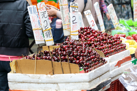 HONG KONG- FEBRUARY 19, 2018-Kawloon - Fruits vendors selling fresh cherry and verity of fruits on street market stalls of Hong Kong,  the seasonal fruits are fresh and reasonably priced のeditorial素材