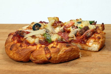 Pizza beef chicken peperoni cheese chilli capsicum onion olive on wooden board の写真素材