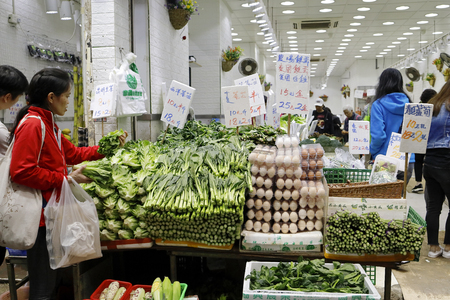 HONG KONG- March 12, 2019 â crowded Chun Yeung Street Wet Market tram line and shops and stalls selling vegetable, meat, fish, fruits etc.のeditorial素材