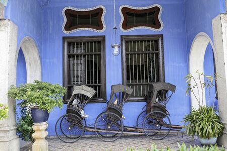 George Town, Penang, Malaysia â June 5, 2019: Cheong Fatt Tze, The Blue mansion was built at the end of 19th century by Chinese merchant. pulled rickshaw at the entrance.のeditorial素材