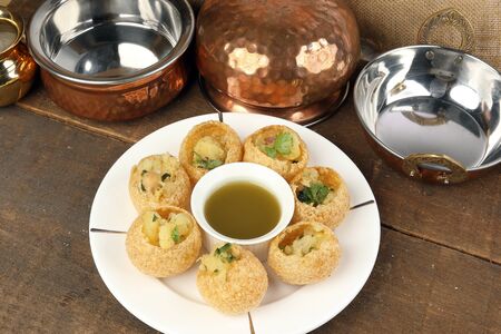 Tadeonal subcontinental street snack food chickpeas potato pani puri fuska with tamarind sauce