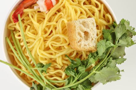 Fresh yellow egg noodle prawn tofu coriander leaf in bowl on whit backgroundの写真素材