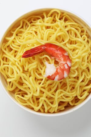 Fresh yellow egg noodle in bowl with prawn on whit backgroundの写真素材