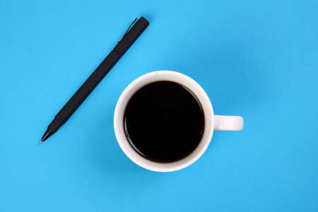 Black coffee cup pen on blue white background top view copy text spaceの写真素材