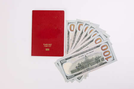 US Dollar currency paper money 100 Hundred dollar bill red passport book on white backgroundの写真素材