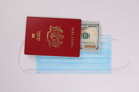 US Dollar currency paper money 100 Hundred dollar bill red malaysian passport book face mask on...
