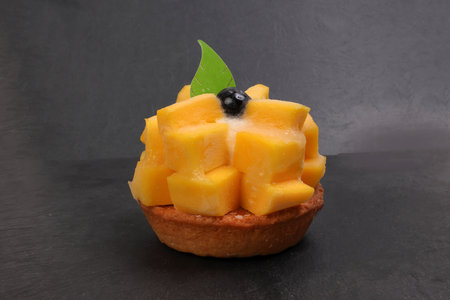 mango fruit tart biscuit on black backgroundの写真素材