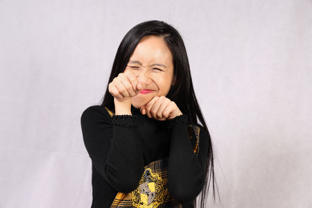 Young attractive southeast Asian woman posing facial expression bunny cute smile fist funny eye closedの写真素材