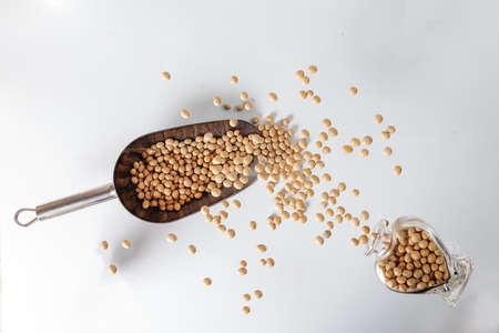 Depth of filed soya been pouring splashing from hart shape glass bottle over metal scoopの写真素材