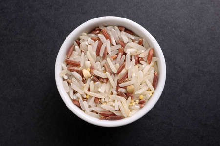 mixed low glycaemic index healthy rice grain basmati millet buckwheat red rice in small white...