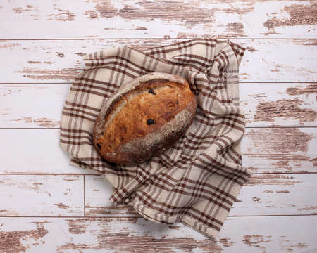 Rustic whole grain artisan bread loaf with cranberry raisin dry fruit nuts wrapped in checkers cloth...