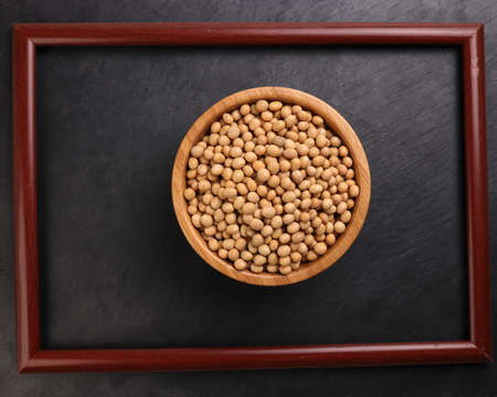 Soyabeans soya beans in wooden bowl picture frame over black background copy text space flat lay top viewの写真素材