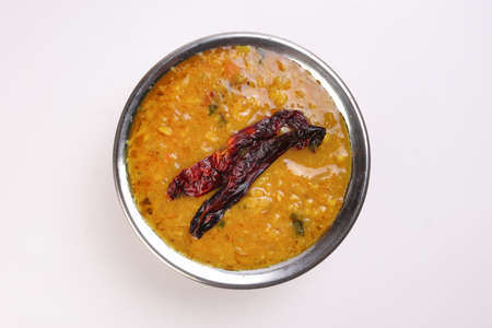 Dal lentil fry tadka with dry chilli in copper pot on white backgroundの写真素材