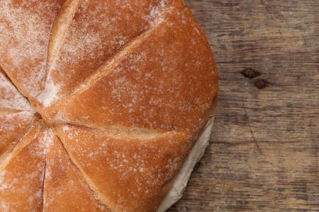 Freshly baked bread loaf round on rustic wood backgroundの写真素材