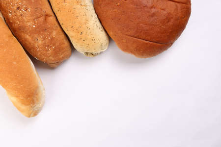 Freshly baked bread loaf bun roll round long mix verity copy text space border frame white backgroundの写真素材