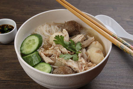 Clear white rice vermicelli beehoon noodle soup with chicken beef meat ball shredded cucumber in...