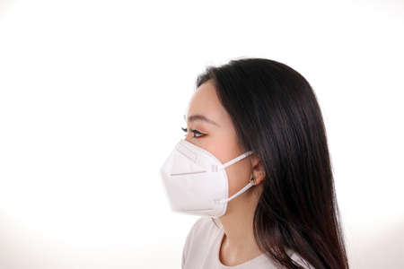 Beautiful young south east Asian woman wearing N95 anti virus bacterial surgical face mask on white...