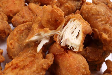Light battered deep fried chicken variety mix pieces pile flaky meat on white background healthy fry