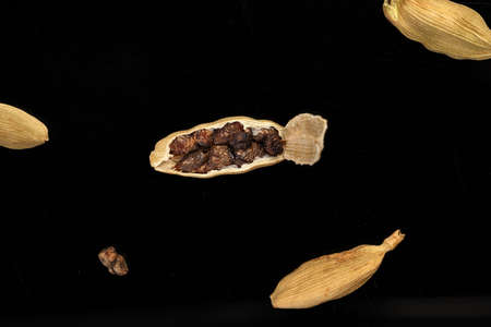 Cardamom fragrant spice seed closeup macro on black background