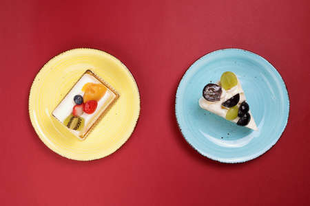 Two slices Green Black Grape Kiwi strawberry blueberry mango fruit cream layer cake pastry on rustic...