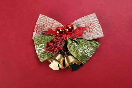 Small Christmas xmas gift bow ribbon Pine Arrangement bell on red background copy text space