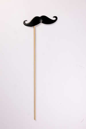 Black moustache shape paper die cut selfie portrait party fun paper prop sticker stick on white backgroundの写真素材