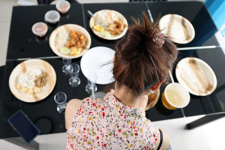 Young southeast asian woman group talk celebrate eating enjoying food rice curry noodle chicken drink cheers on dining table arraign foodの写真素材
