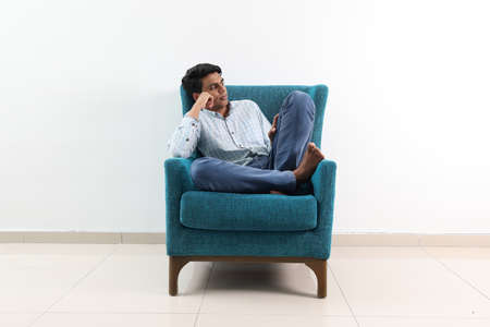 Southeast Asian young man special need medical down adhd autism syndrome sit pose look think work study emotion feelingsの写真素材