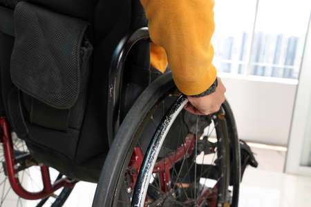 South east Asian malay middle aged disabled man on wheelchair looking sitting in front of balcony...