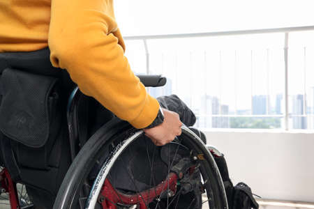 South east Asian malay middle aged disabled man on wheelchair looking sitting in front of balcony...