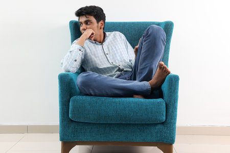 Southeast Asian young man special need medical down adhd autism syndrome sit pose look think work study emotion feelingsの写真素材