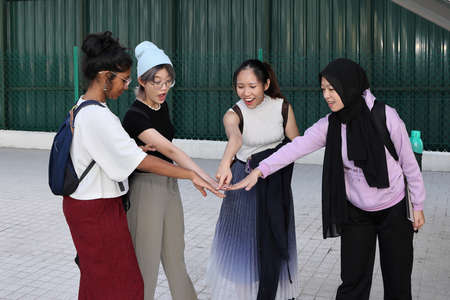 Four group young attractive Asian multi ethnic woman friends colleagues students talk walk discuss...