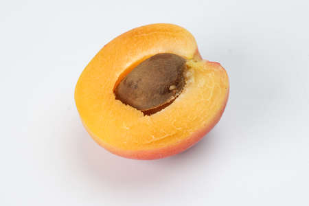 Fresh ripe juicy yellow orange red apricot cut half slice seed on white background