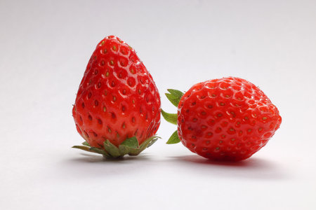 Beautiful ripe shiny red strawberry on white background macro closeup detailsの写真素材
