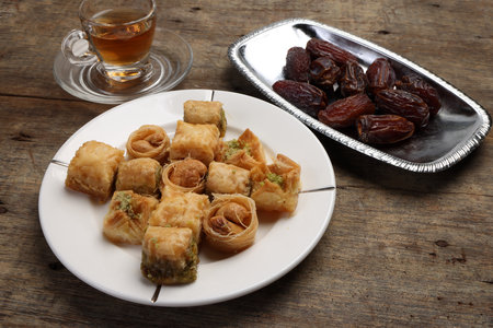 Layered stuffed pastry Baklava middle eastern sweet dessert dry ripe sweet date fruit tea in...