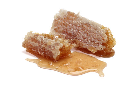 Sticky liquid honey natural geomatic hexagon honeycomb macro closeup on white backgroundの写真素材