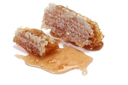 Sticky liquid honey natural geomatic hexagon honeycomb macro closeup on white backgroundの写真素材