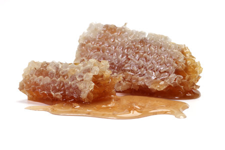 Sticky liquid honey natural geomatic hexagon honeycomb macro closeup on white backgroundの写真素材