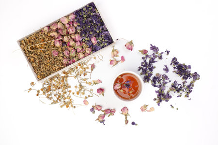 Dry flower tea rose bud butterfly pea chamomile flower transparent ceramic glass tea cup on white backgroundの写真素材