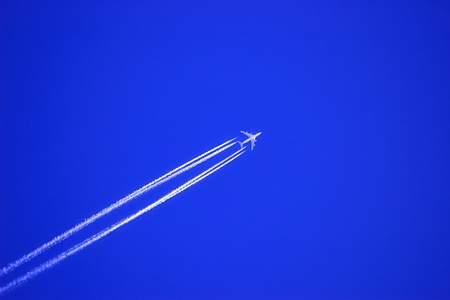 Jet plane at high altitude in the deep blue sky.