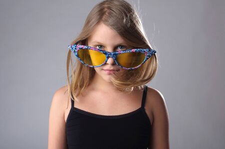 Little girl in funny big glasses in studio.