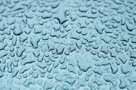 Close up of water drops on the metallic paited metal.の写真素材