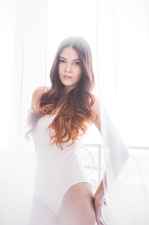 beautiful girl in a white body plays with tulleの写真素材