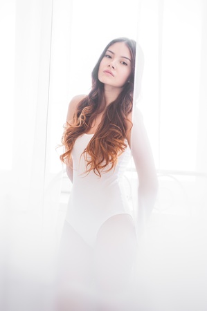 beautiful girl in a white body plays with tulleの写真素材