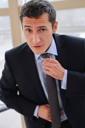 Manager corrects tie with a facial expression, implying a further showdownの写真素材
