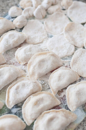 An image of raw dumplings and pieces of dumplings on the boardの写真素材