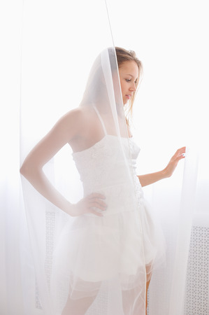 beautiful girl in a white body plays with tulleの写真素材