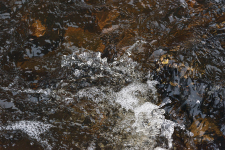A raging stream of water in a swift stream.の写真素材