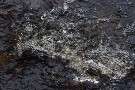 A raging stream of water in a swift stream.の写真素材